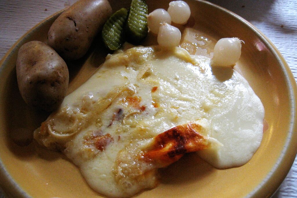 Raclette with boiled potatoes, pickles and onions